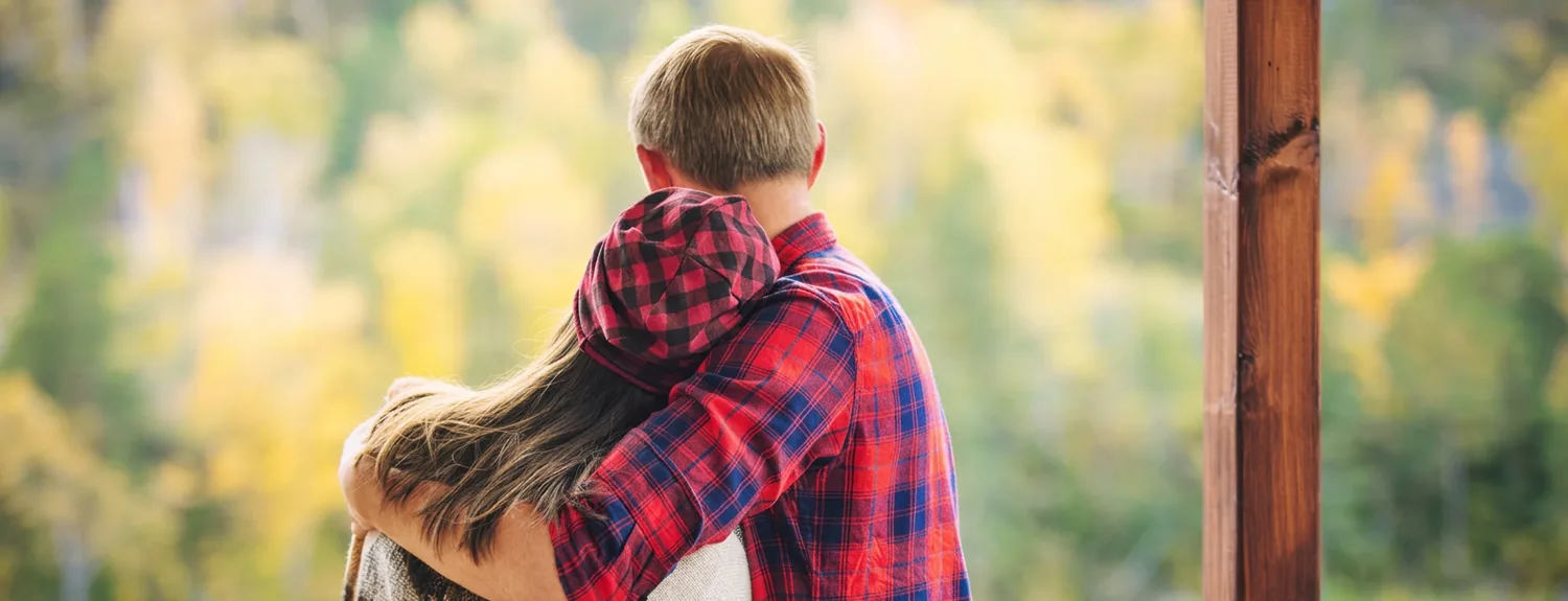 A couple embracing outside their new Muskoka home