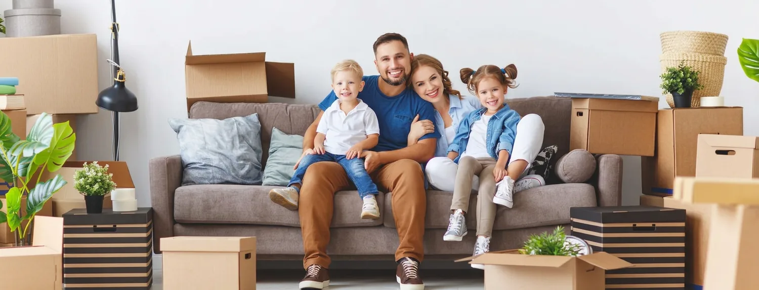 A family relaxing on the couch among moving boxes